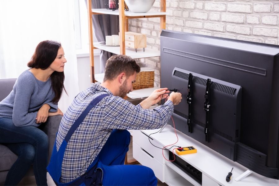 Professional TV repair technician fixing a Smart TV in a New Jersey home